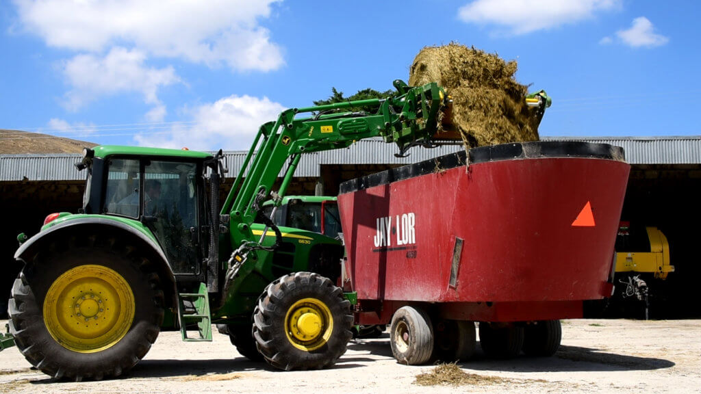 LX104 Mounted Bale Unroller - Tractor-feeding-into-TMR