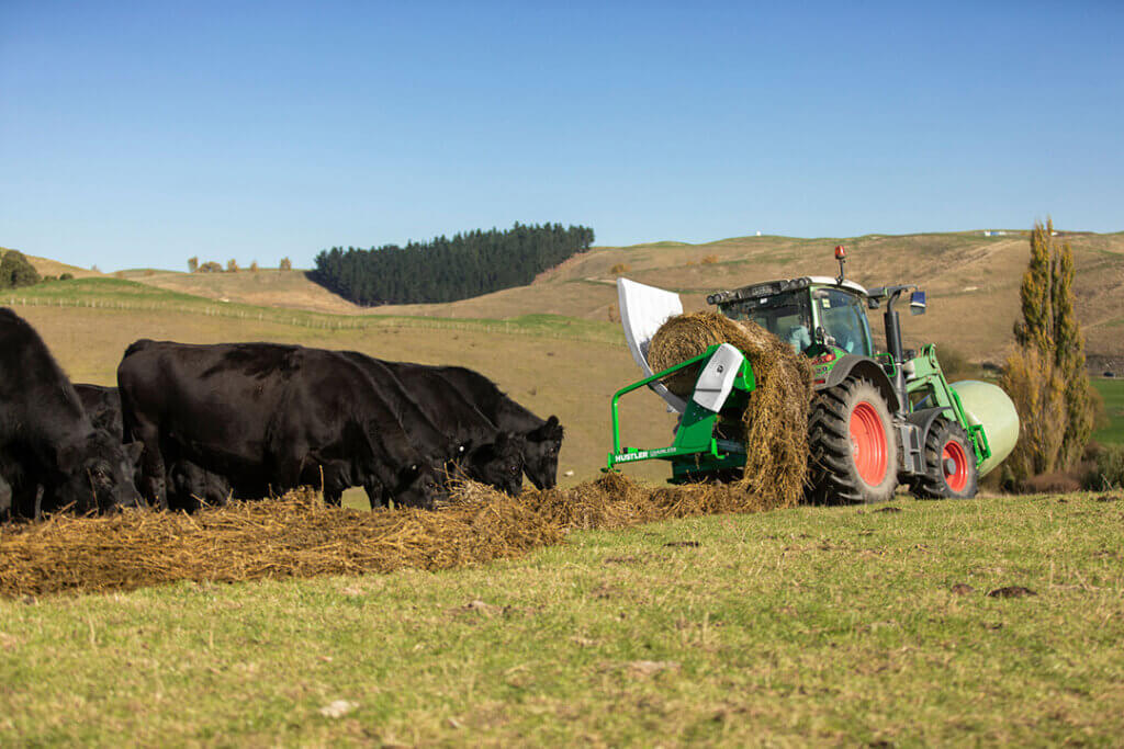 Hustler Chainless LX104 feeding bale to cattle