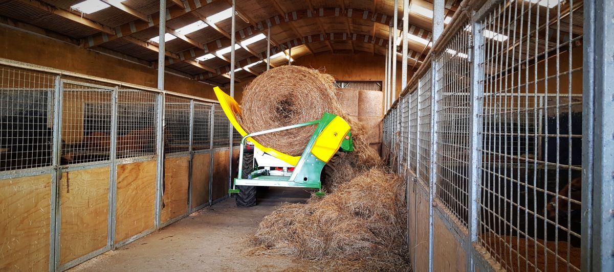 chainless-x2500-bale-feeder-feeding-in-barn.jpg